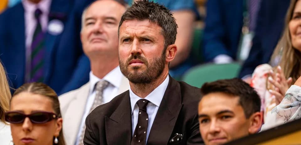 Man in suit watching tennis match in audience