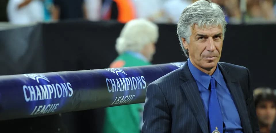 Coach seated near Champions League branding during match