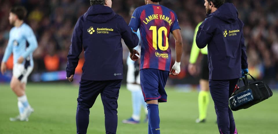 Lamine Yamal being assisted off the pitch by staff