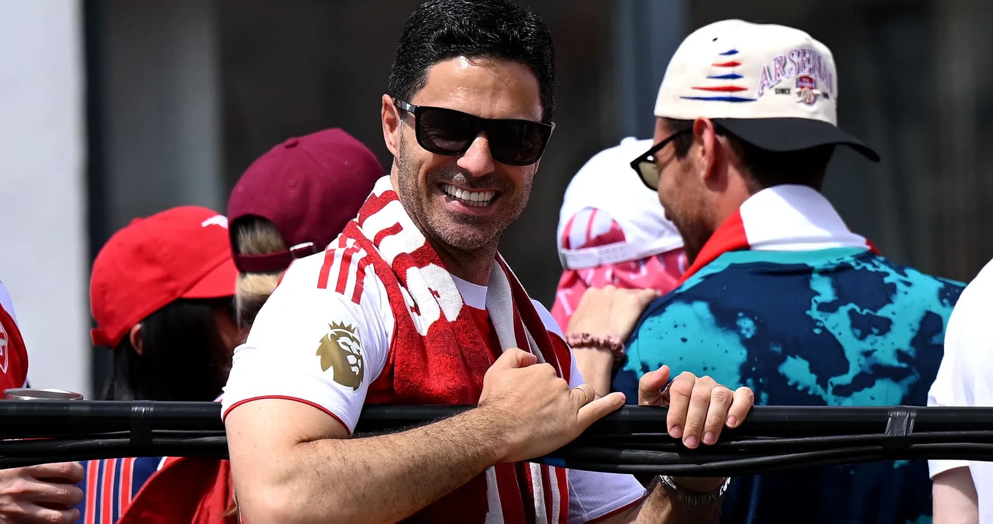 Man in Arsenal shirt smiling with fans