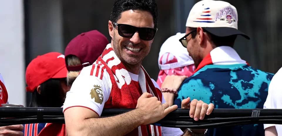 Man in Arsenal shirt smiling with fans