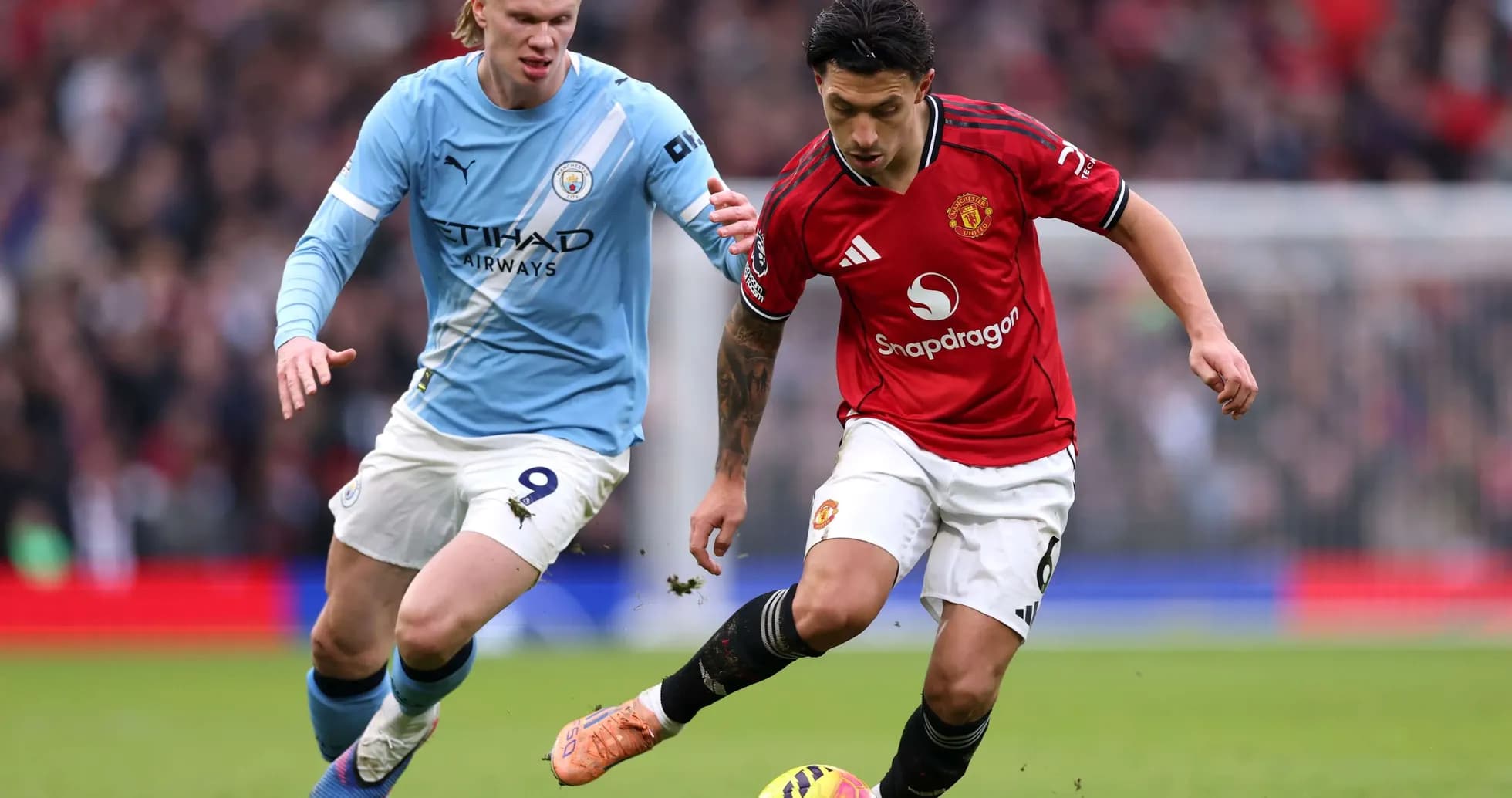 Manchester United player dribbling against Manchester City