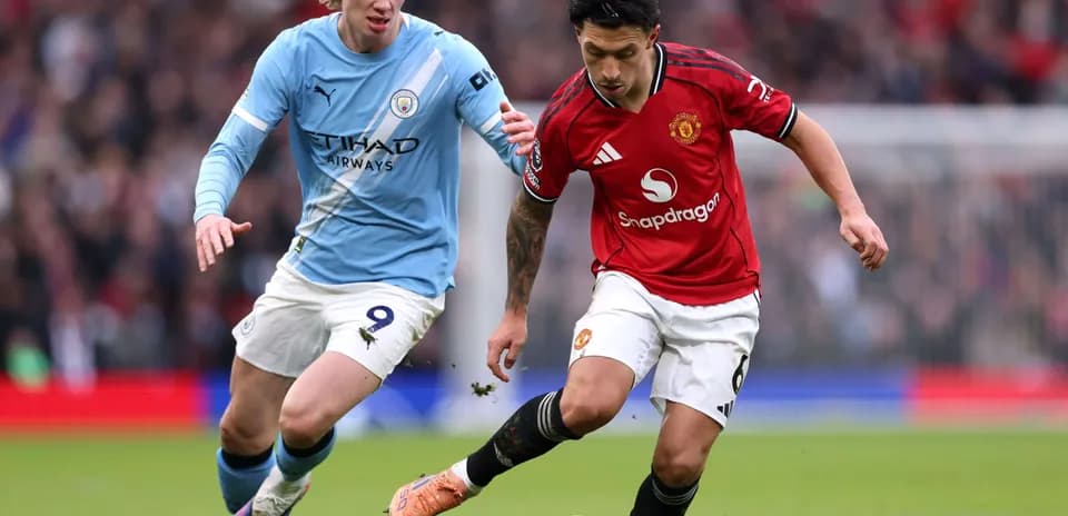 Manchester United player dribbling against Manchester City