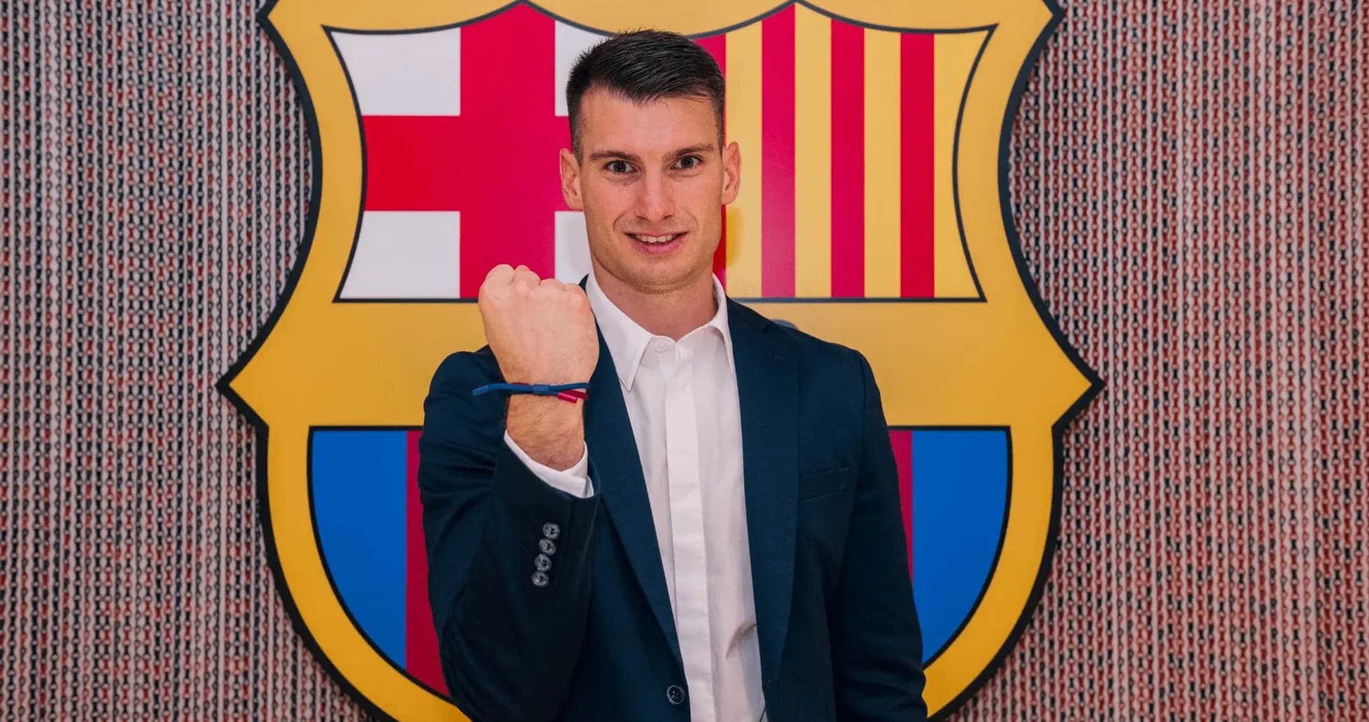 Player posing in front of FC Barcelona logo