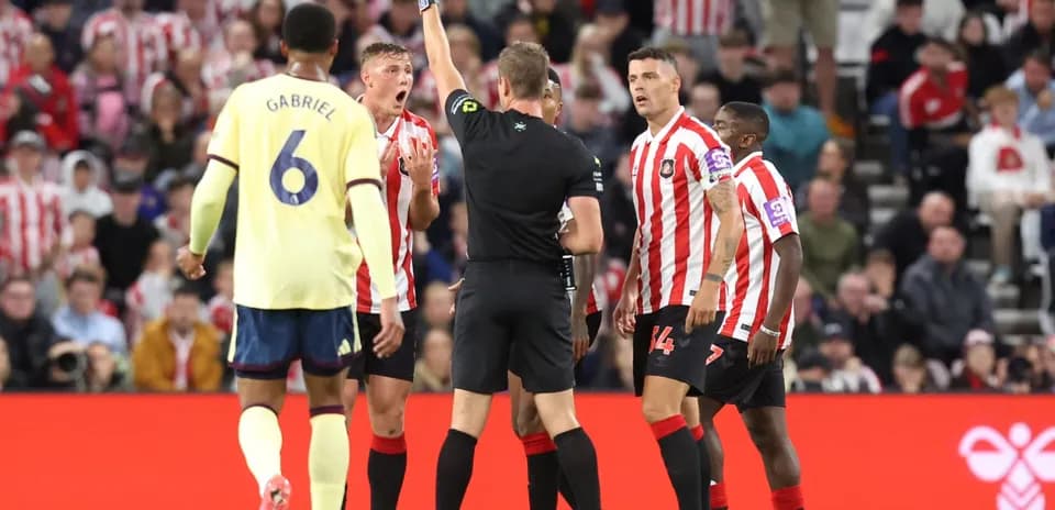 Referee showing yellow card to Sunderland player