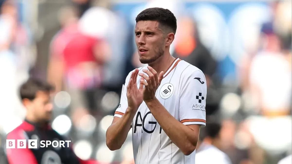Player applauding fans after match in Swansea kit