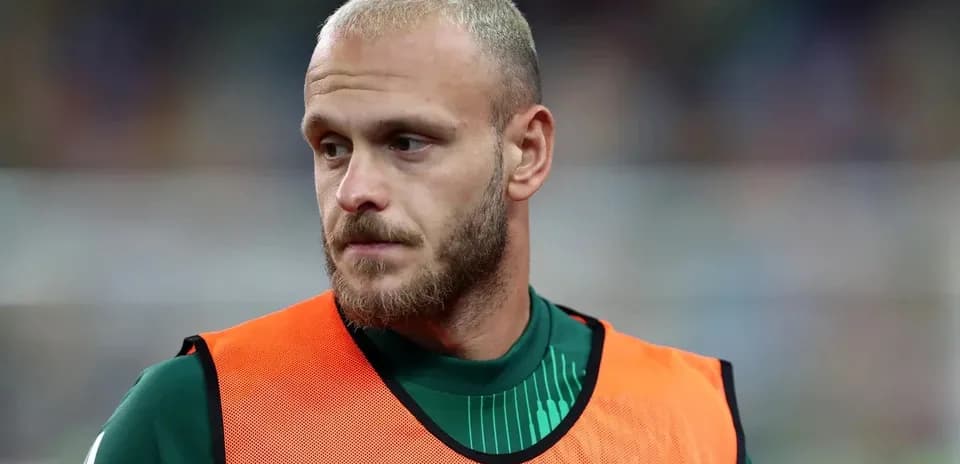 Goalkeeper wearing training vest on sidelines