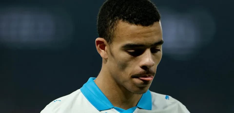 Player in Marseille jersey looking down thoughtfully