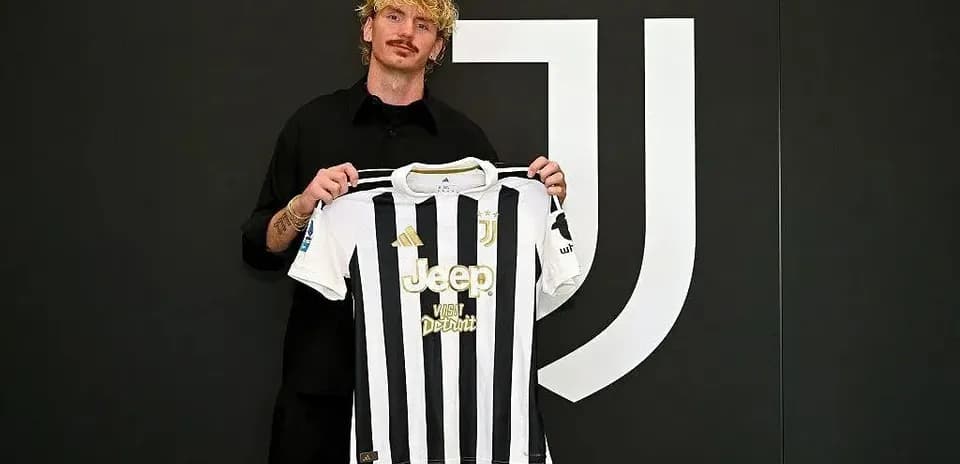 Player holding Juventus jersey during signing ceremony