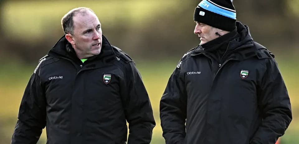 Two coaches discussing strategies on the field