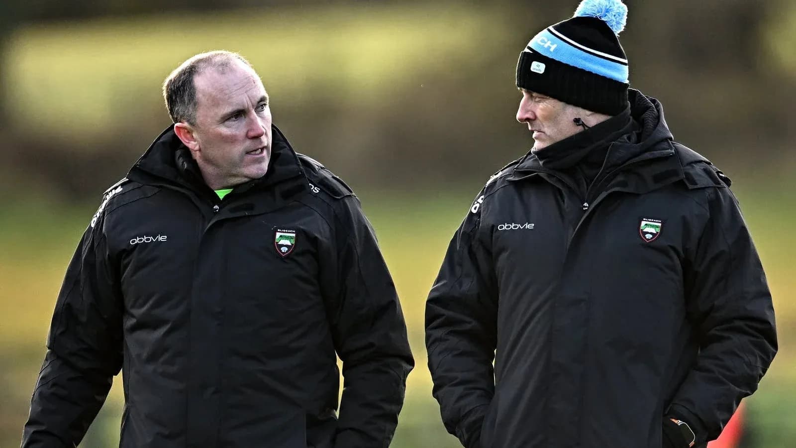 Two coaches discussing strategies on the field