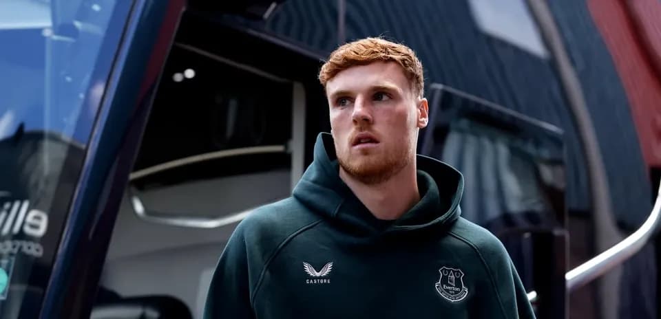 Player in Everton hoodie outside team bus