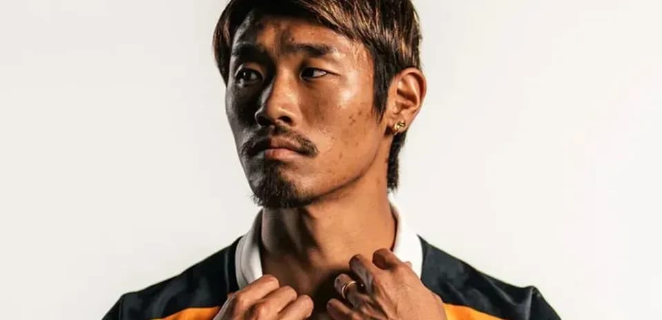Player adjusting collar in studio portrait