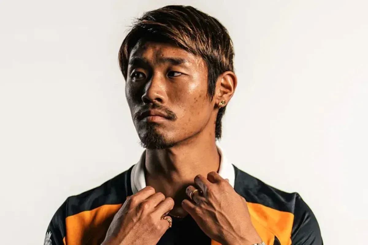 Player adjusting collar in studio portrait