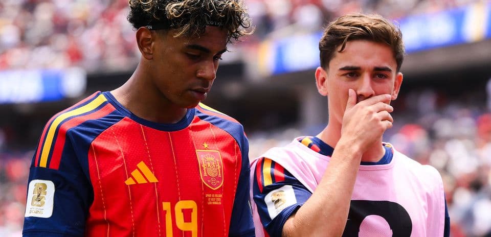 Two Spain players on the sidelines during match