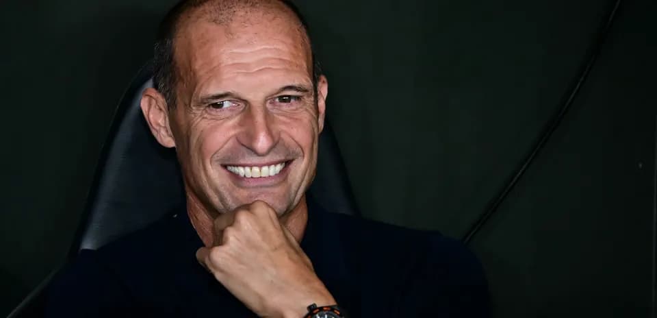Coach smiling while seated during press event