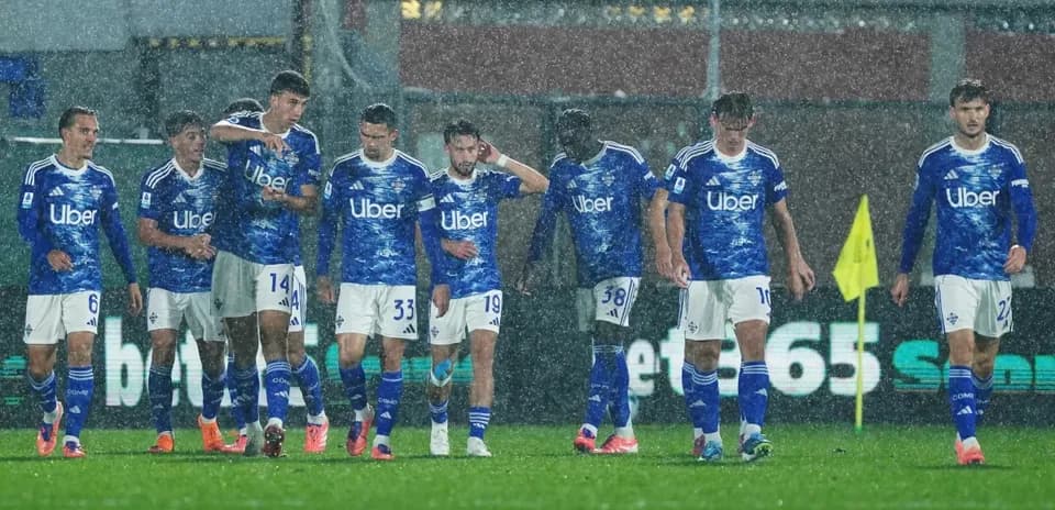 Como players walking on a rainy pitch