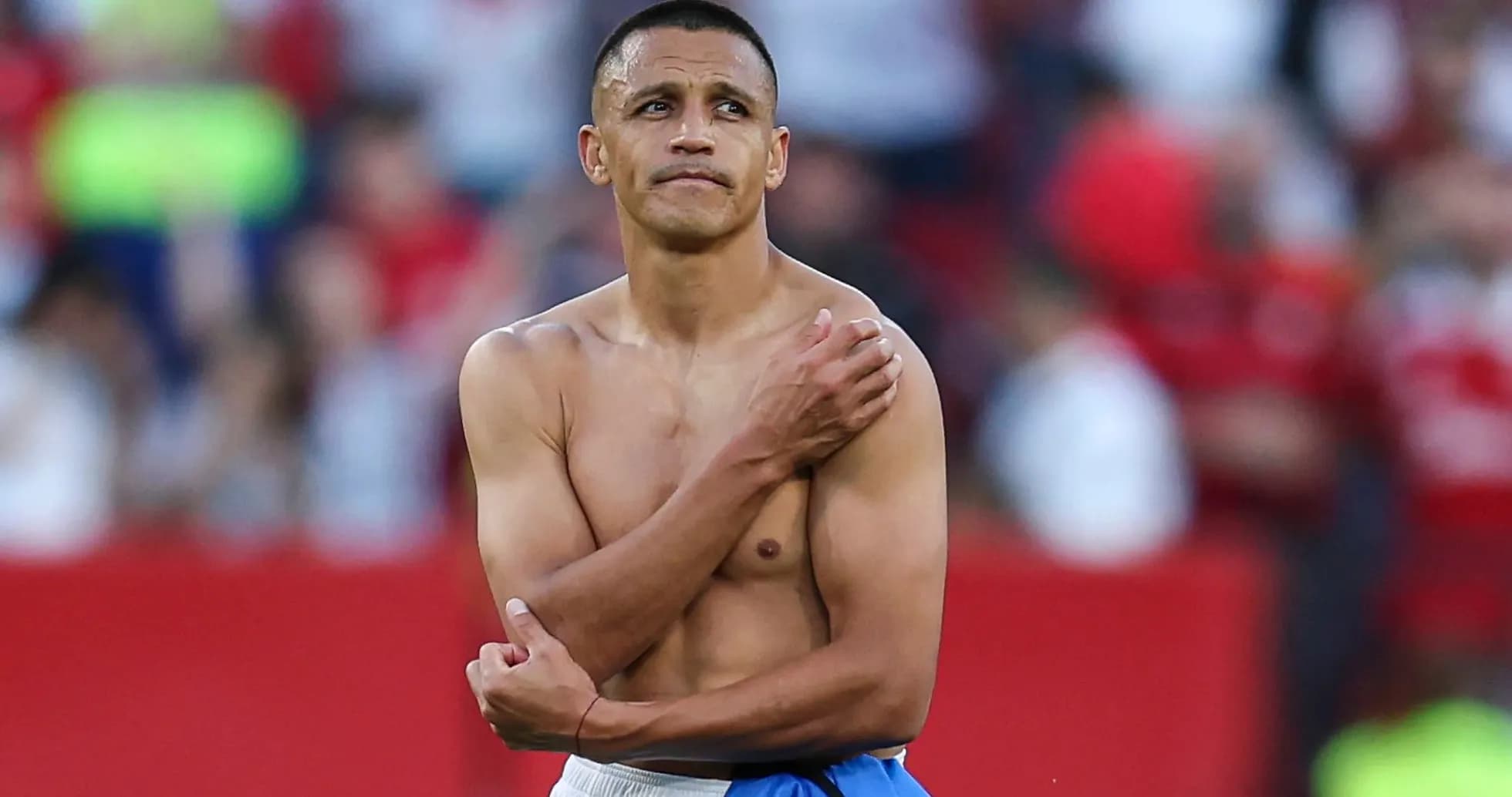 Player with no shirt holding shoulder after match