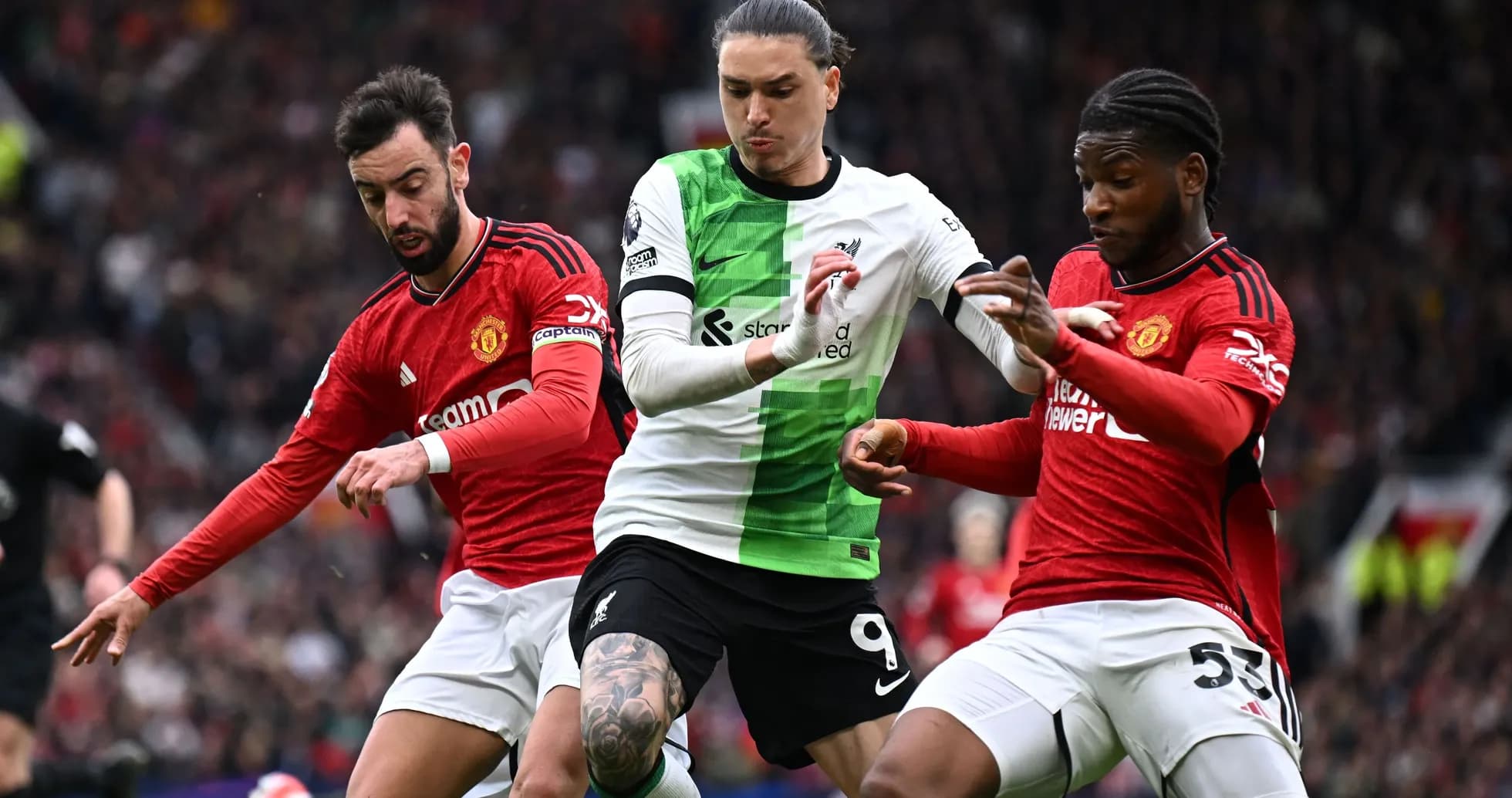 Players from Manchester United and Liverpool contesting the ball