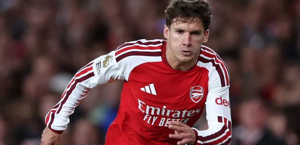 Player in red Arsenal kit sprinting on the pitch