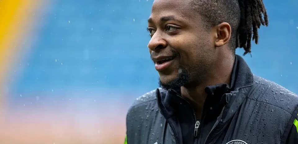 Player in rain, wearing Celtic Football Club jacket