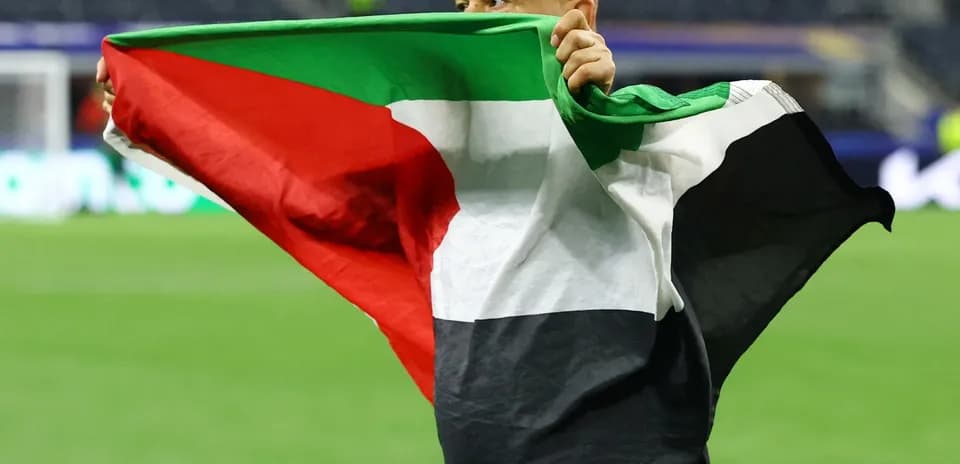 Person celebrating with a flag on the field