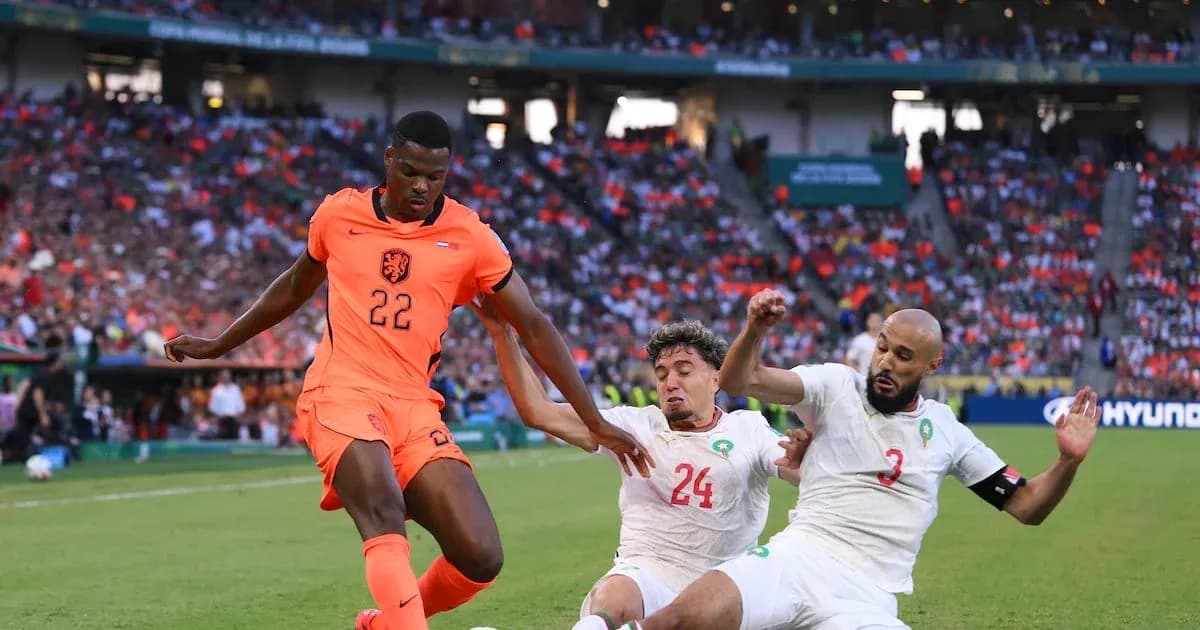 Player 22 of Netherlands evading two Moroccan defenders