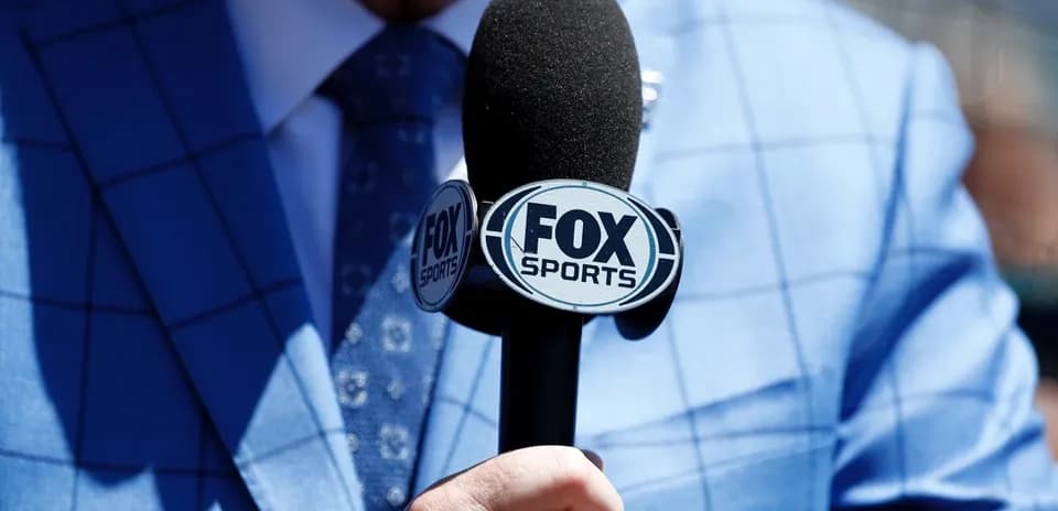 Microphone with FOX Sports logo held by person