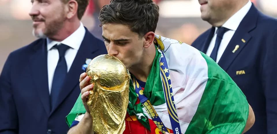 Player kissing the World Cup trophy on podium