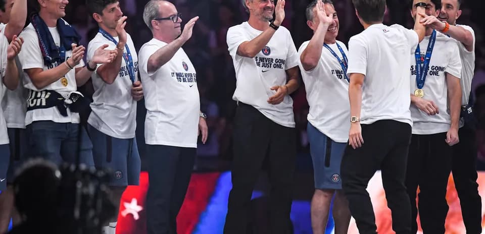 Coaches and staff celebrating on stage with medals