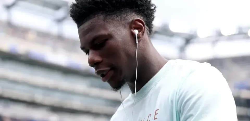 Player wearing earbuds on stadium sidelines
