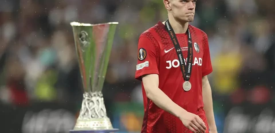 Player walking past UEFA Europa League trophy