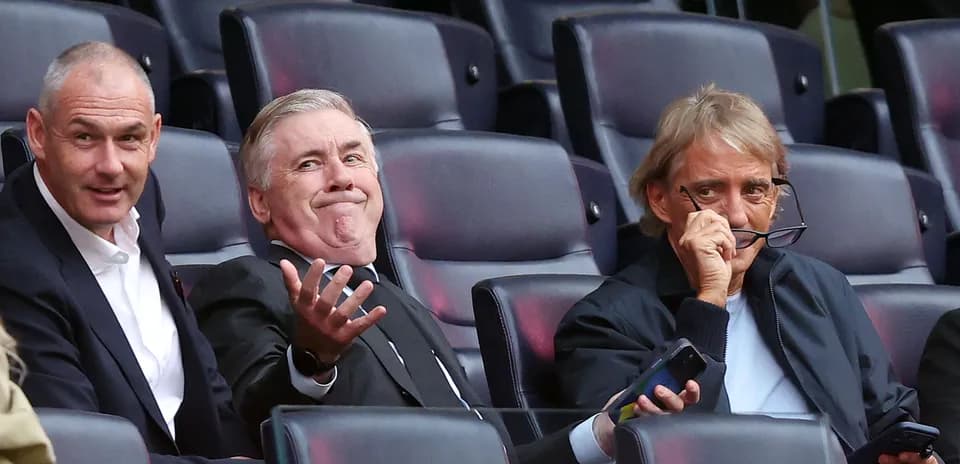 Three men seated in stadium, watching event