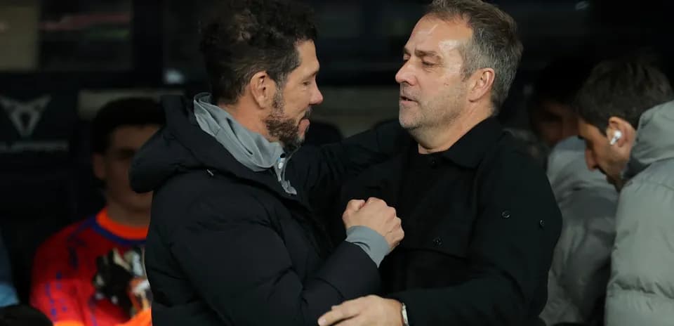 Two coaches sharing a handshake on the sidelines