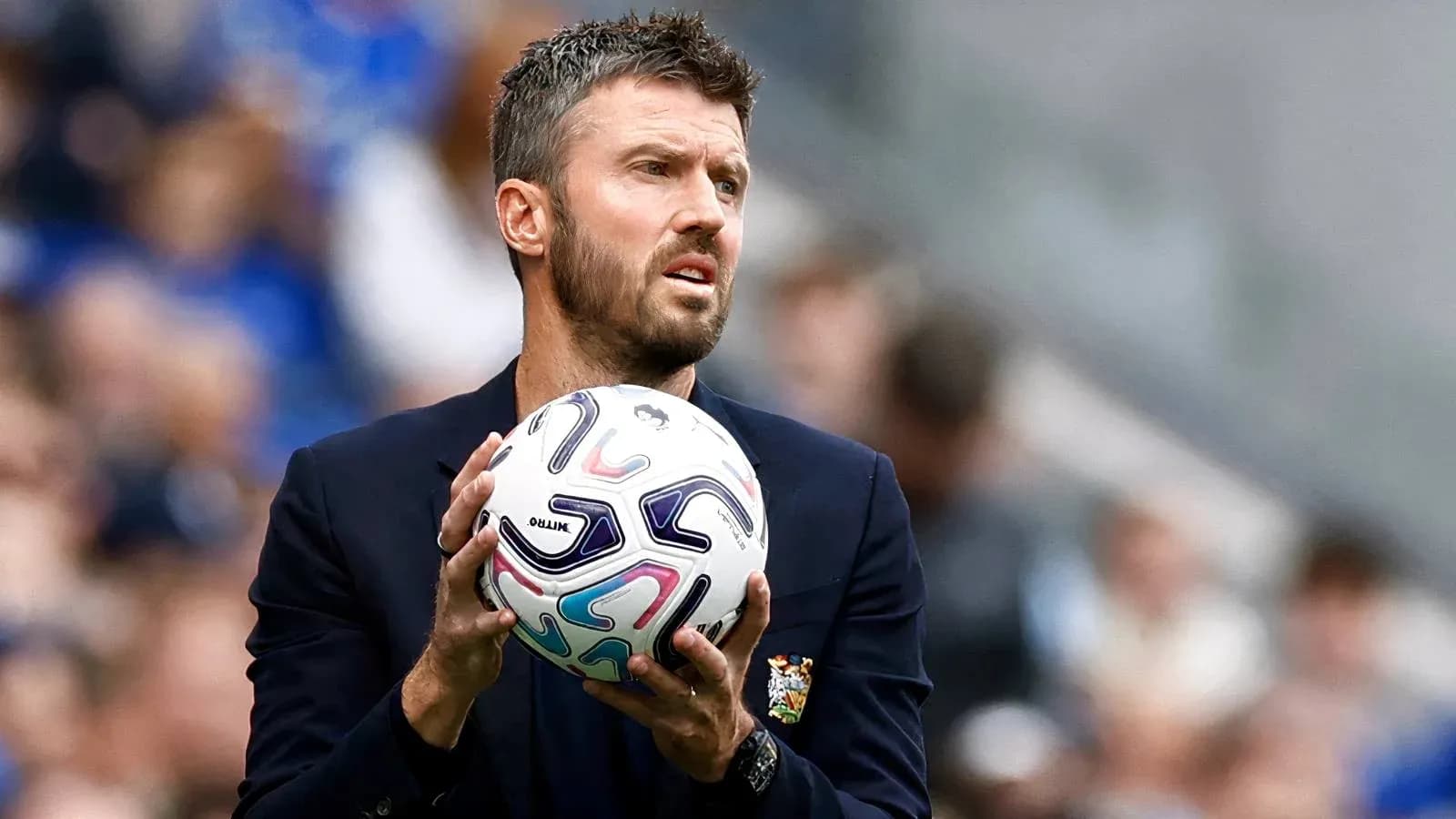Coach holding ball during a match on the sidelines