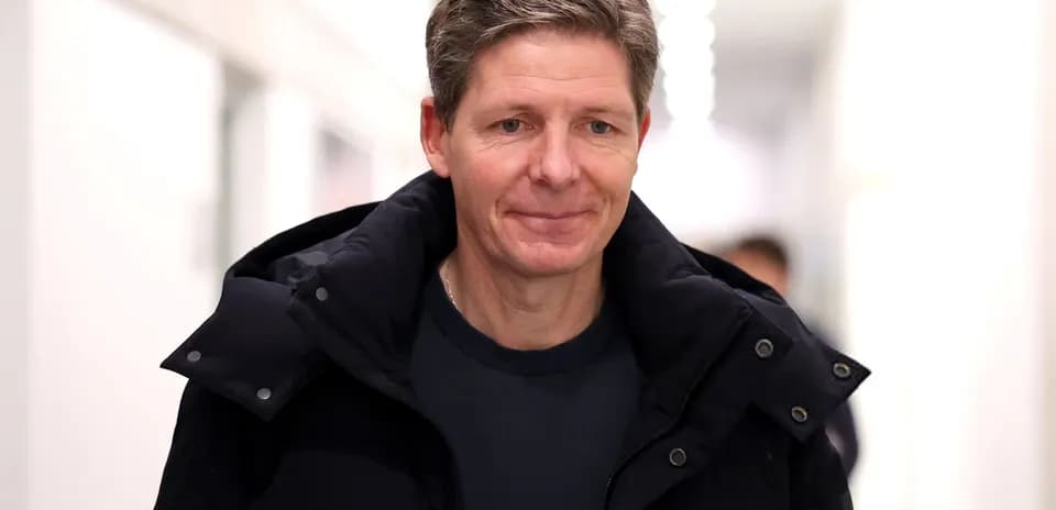 Person walking in a corridor wearing a dark jacket