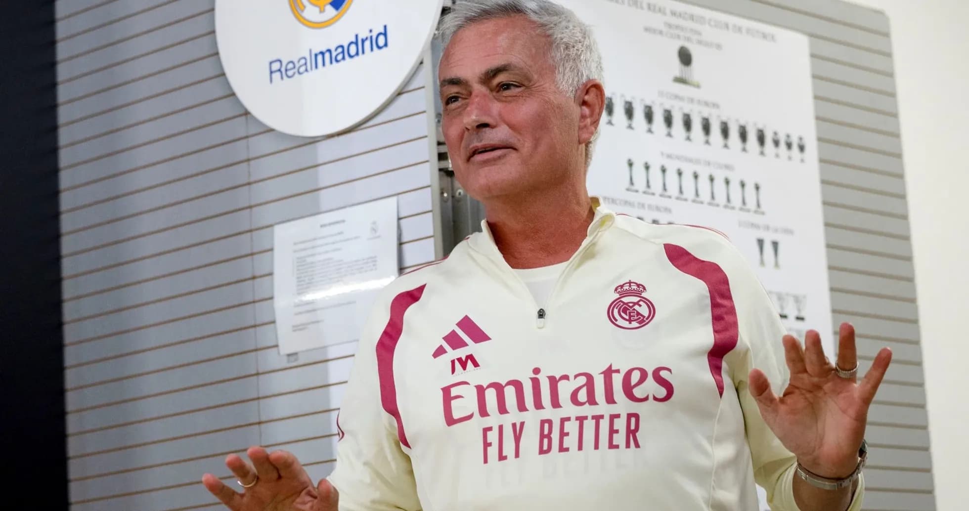 Coach speaking in front of Real Madrid emblem