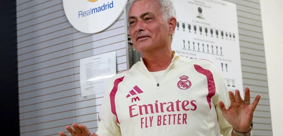 Coach speaking in front of Real Madrid emblem