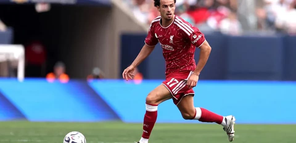 Player in red Liverpool kit running with the ball