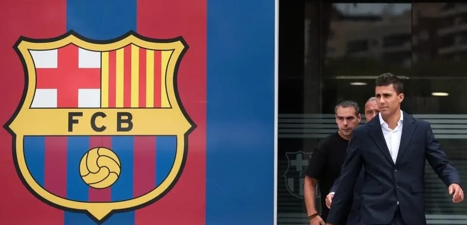 Player walking past FC Barcelona logo entrance