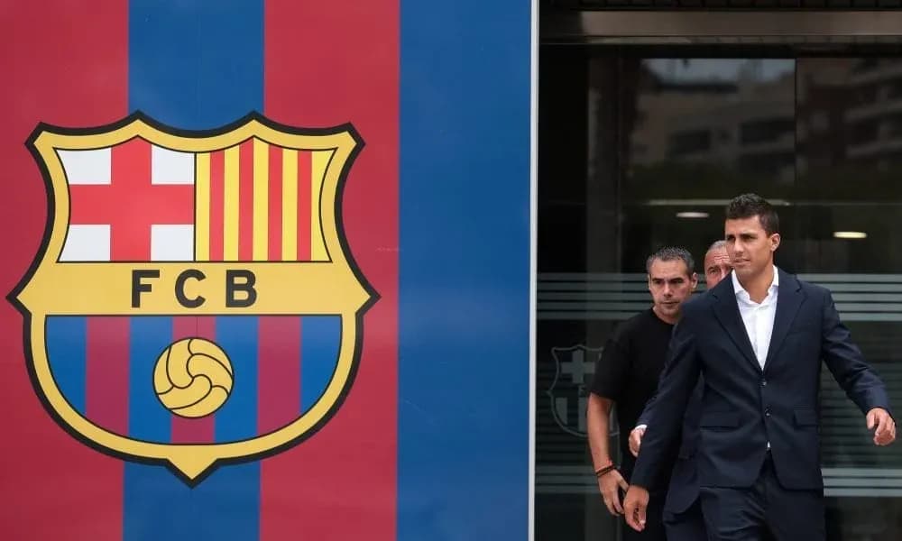Player walking past FC Barcelona logo entrance