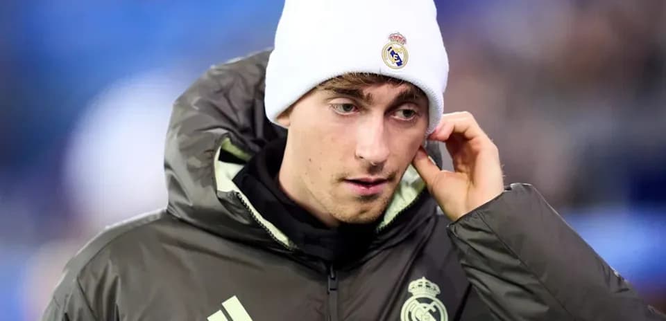 Player in Real Madrid jacket and beanie on field