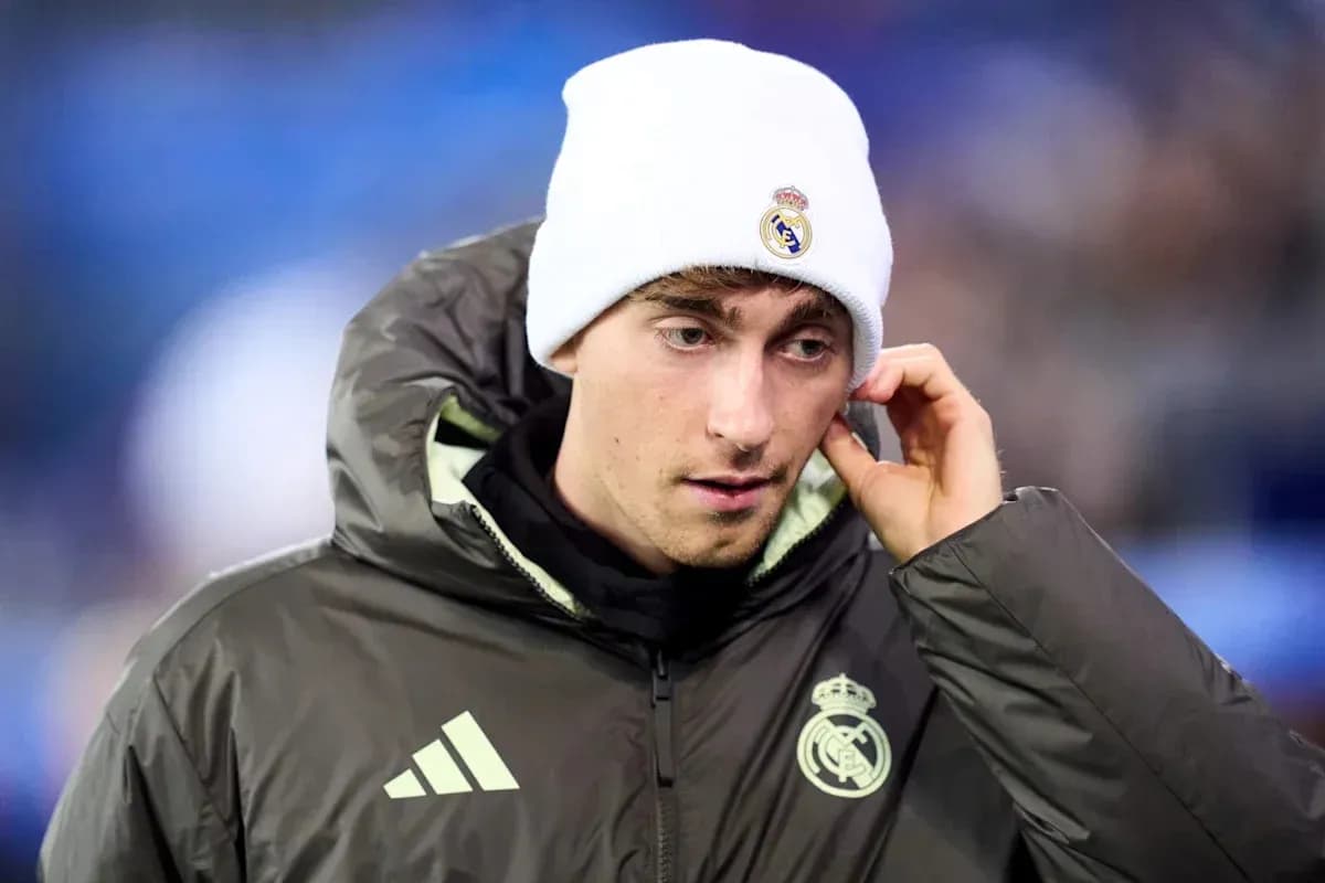 Player in Real Madrid jacket and beanie on field