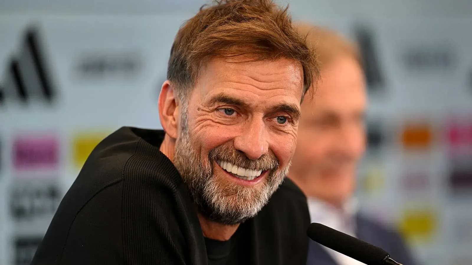 Manager smiling at press conference podium