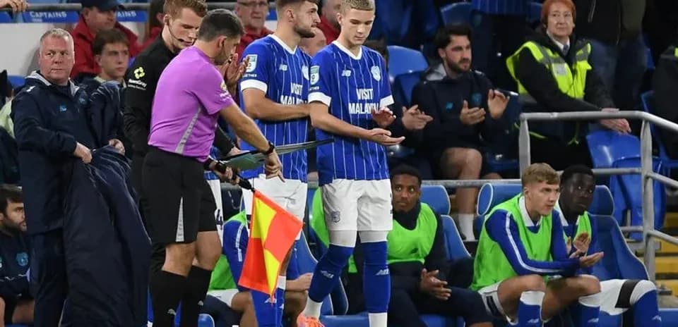 Player substitution during football match on sidelines
