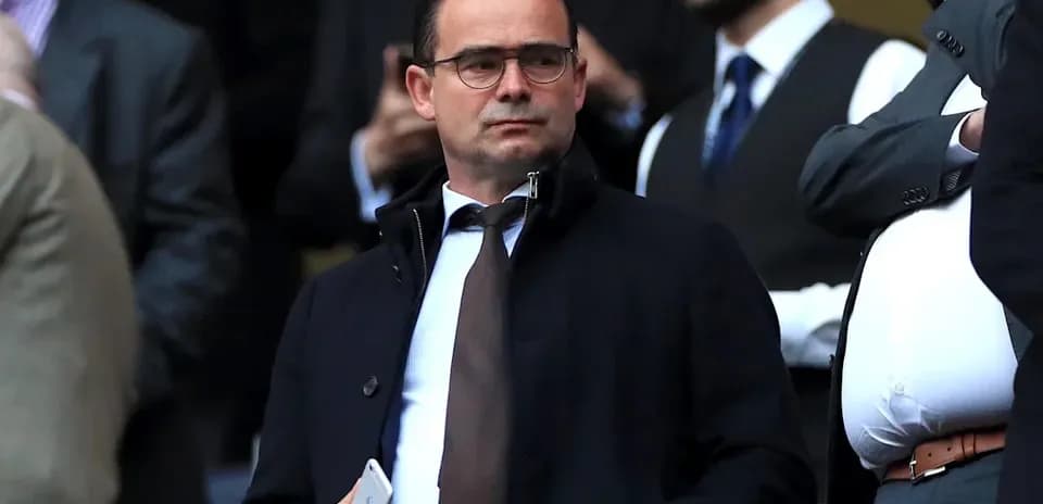 Man in suit observing from the stands at a match