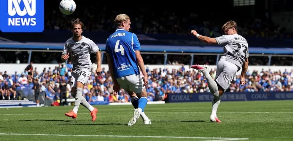 Player striking the ball during football match action