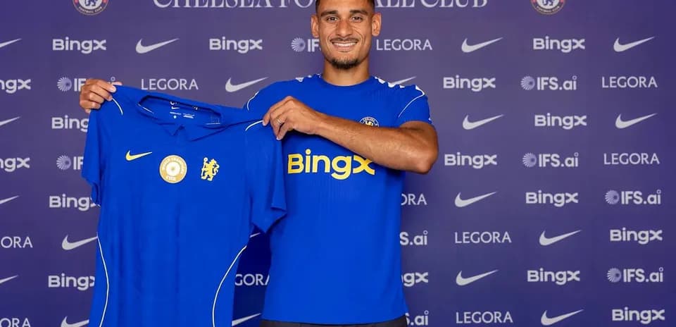 Player holding Chelsea jersey during announcement event