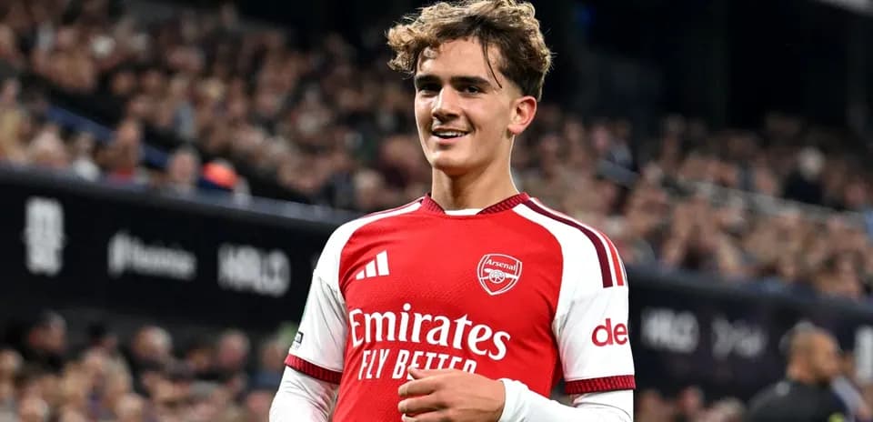 Player in Arsenal kit smiling on the field