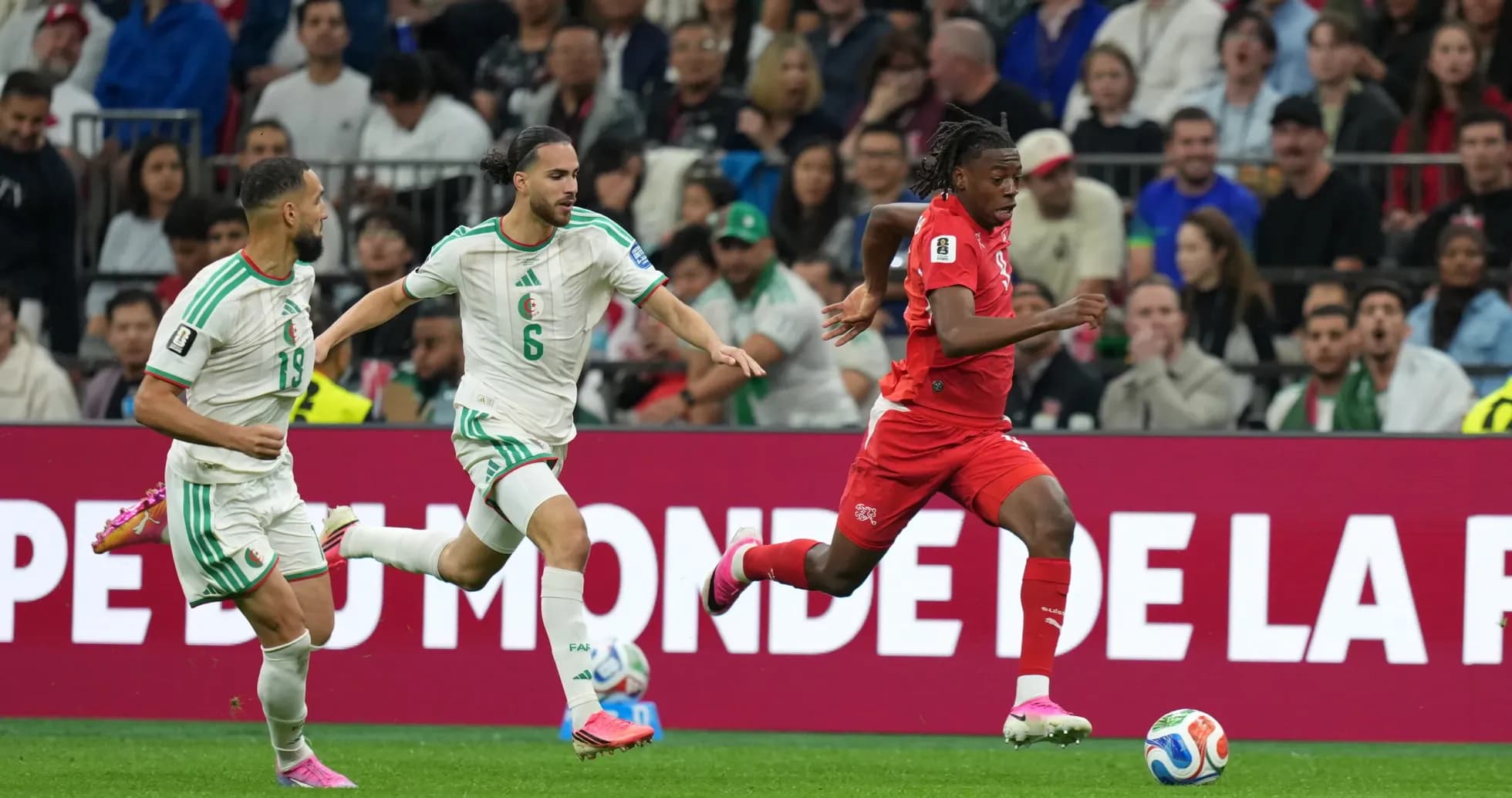 Switzerland player sprinting against Algeria defenders
